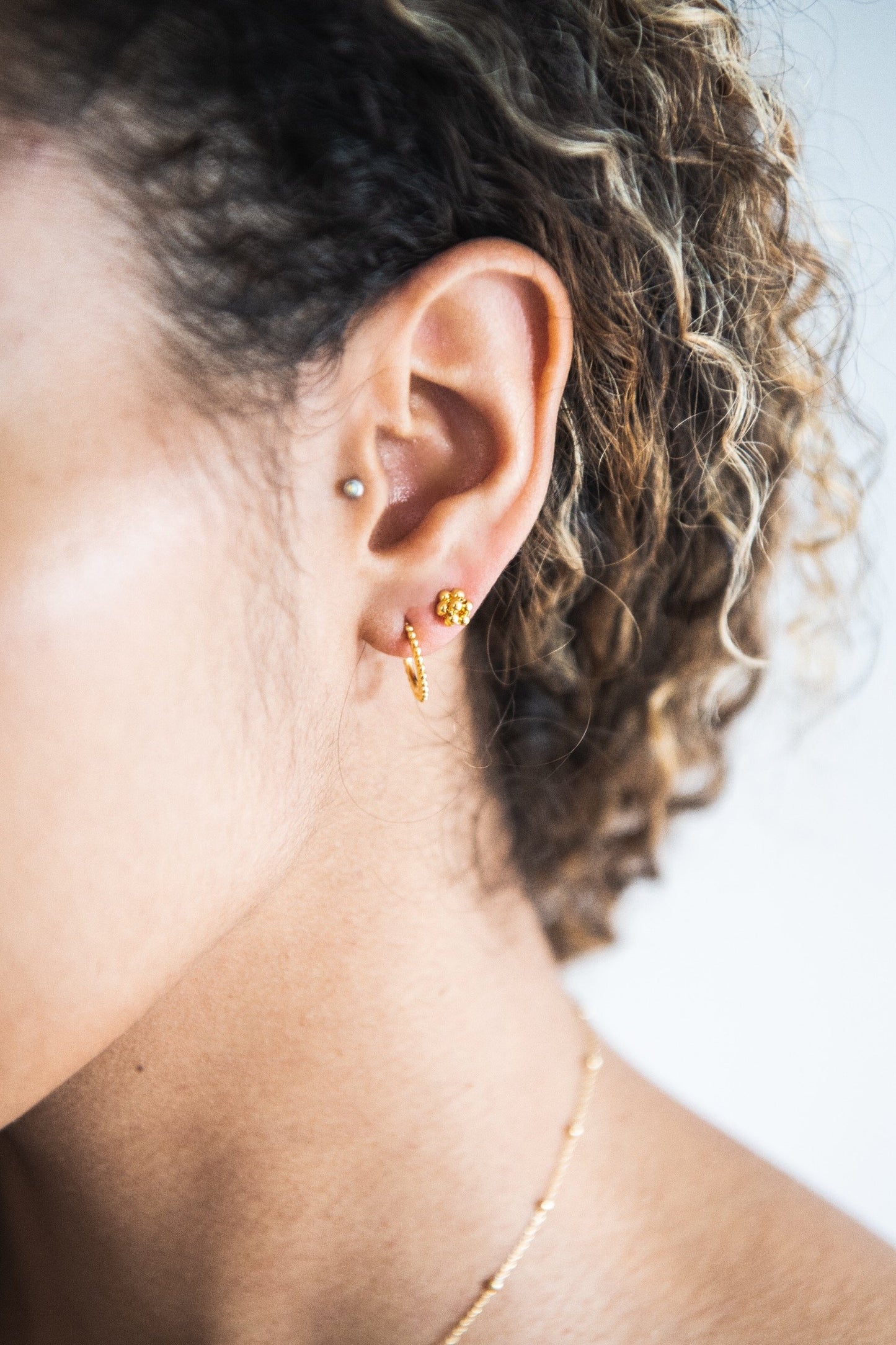 Close up of woman wearing Indira Hooped Stud earring