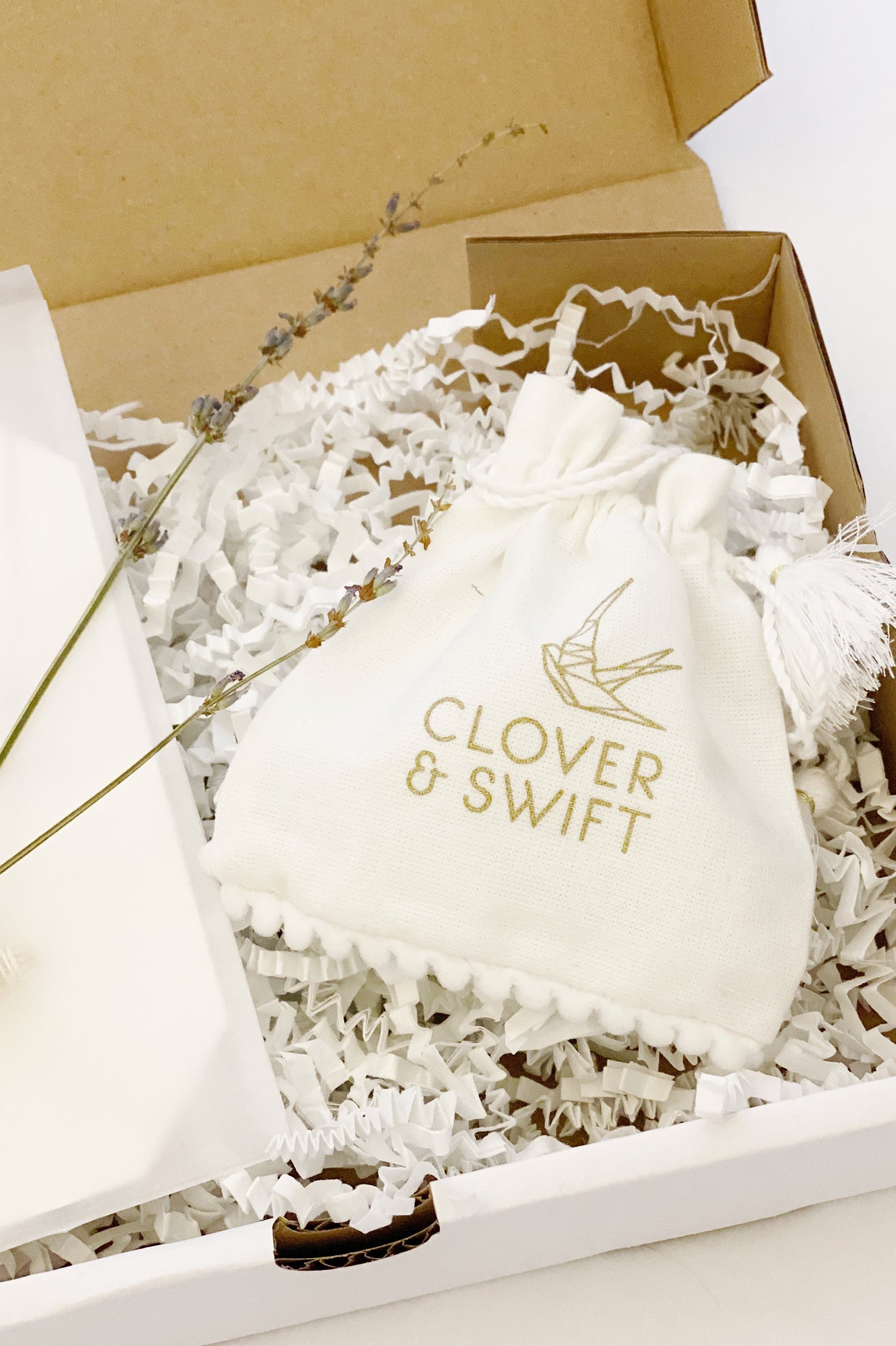 Small white drawstring pouch with Clover & Swift printed on it in a box
