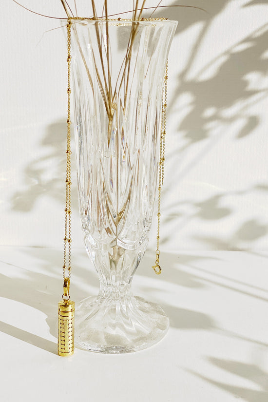 Lexi Wishing Locket with chain draped over vase