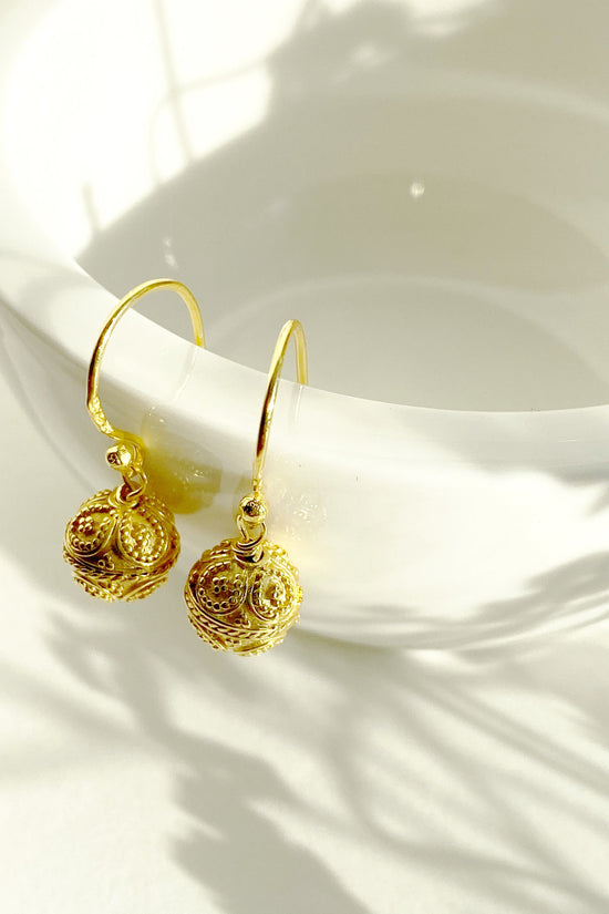 Close up of Mini Bali Harmony Ball Earrings hanging over rim of vessel