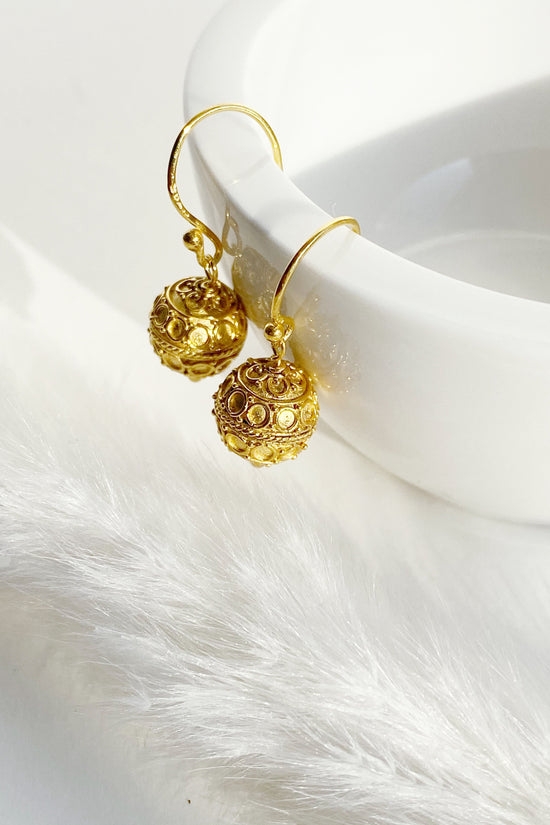 Circle Design Harmony Ball Earrings hanging from a rim