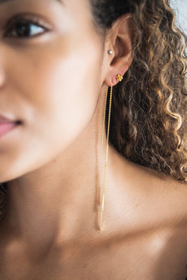 Close up of woman wearing Aretha Long Gold Feathered Threader Earring